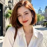 Illustrative photo of a young woman with a brown bob in a white shirt on a sunny street